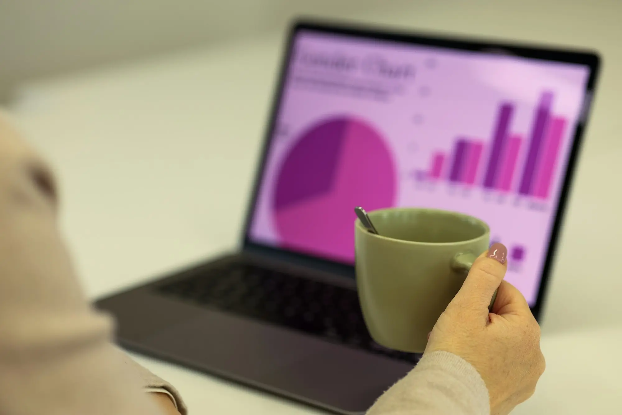Key business numbers on a laptop dashboard beside a coffee